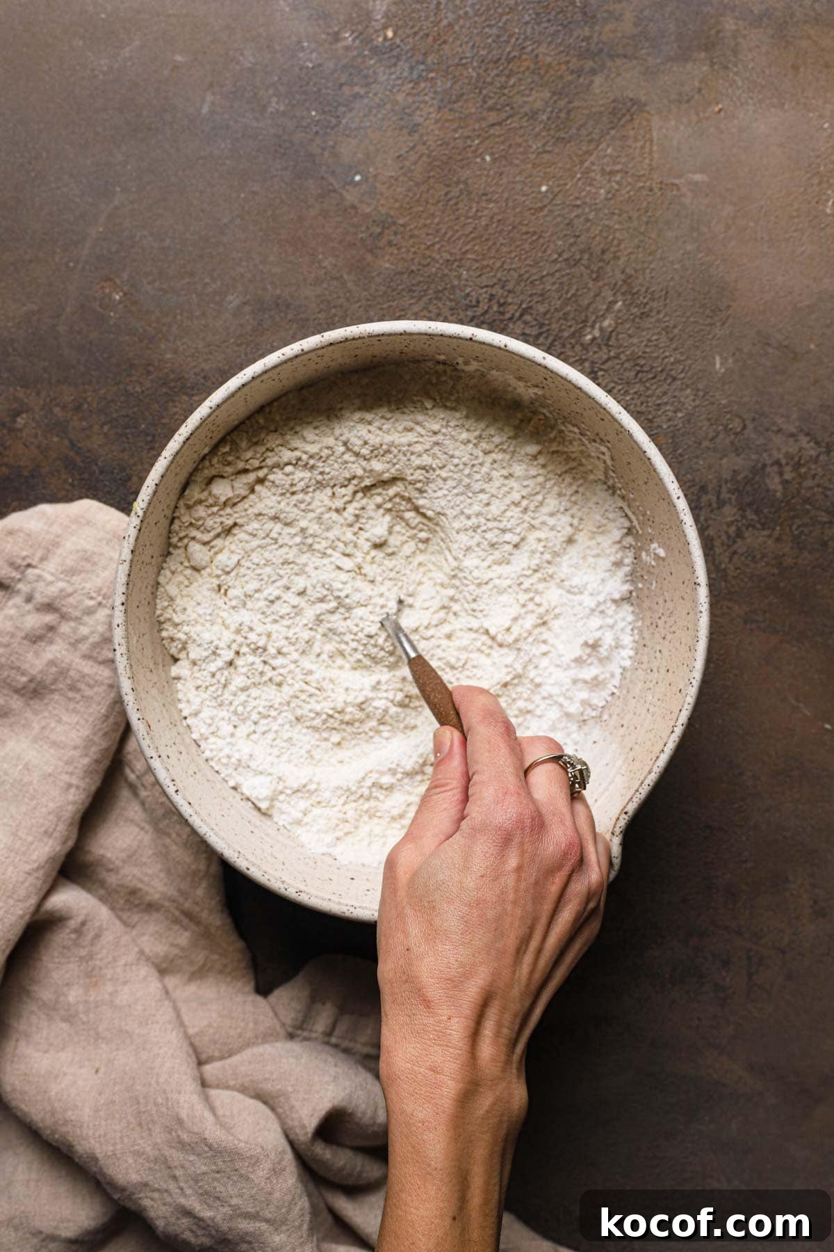 Italian Pasta Frolla Shortcrust Recipe for Tarts & Cookies 7 A hand mixing flour in a large bowl.