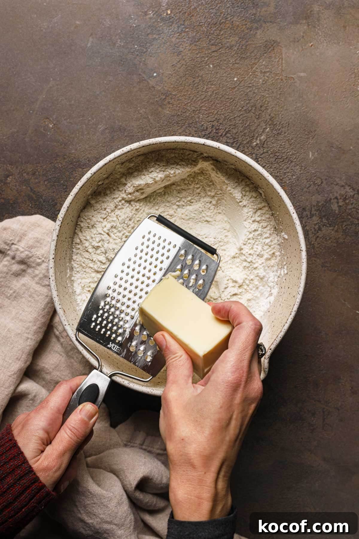 Italian Pasta Frolla Shortcrust Recipe for Tarts & Cookies 8 A hand grating butter into a large bowl with flour.