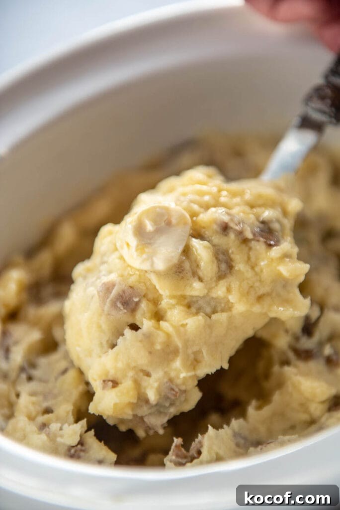 Creamy Dairy-Free Mashed Potatoes Recipe 7 scooping a spoonful of mashed potatoes out of slow cooker