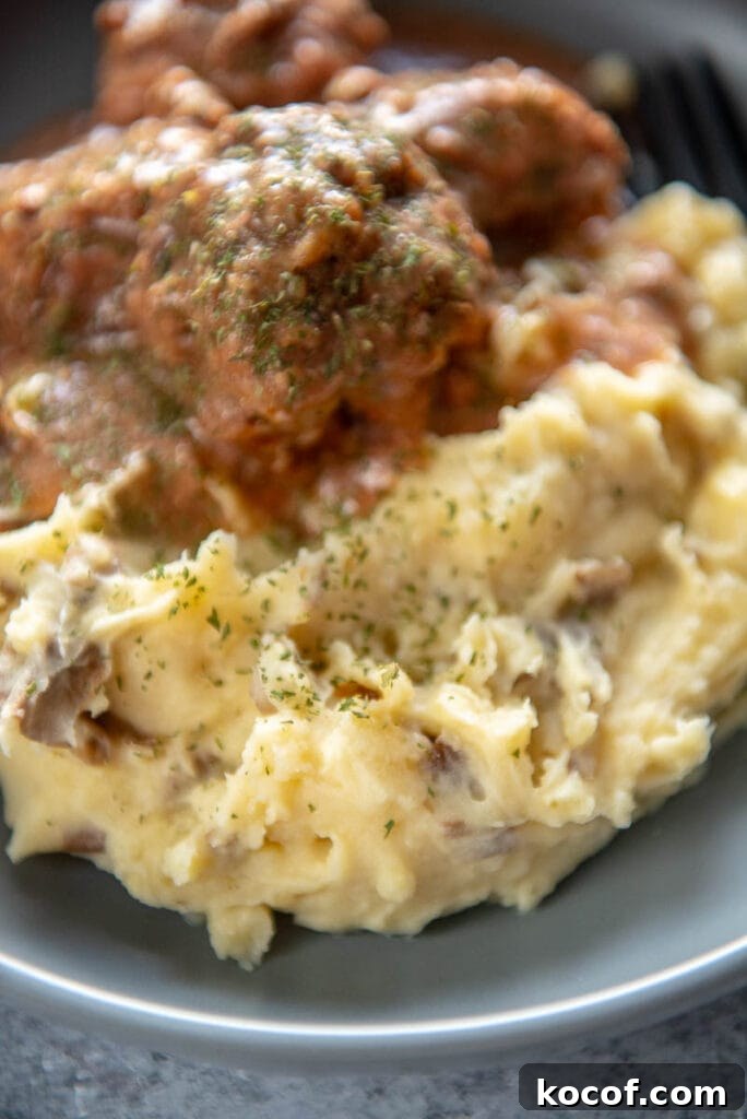 Creamy Dairy-Free Mashed Potatoes Recipe 8 mashed potatoes next to meatballs on plate