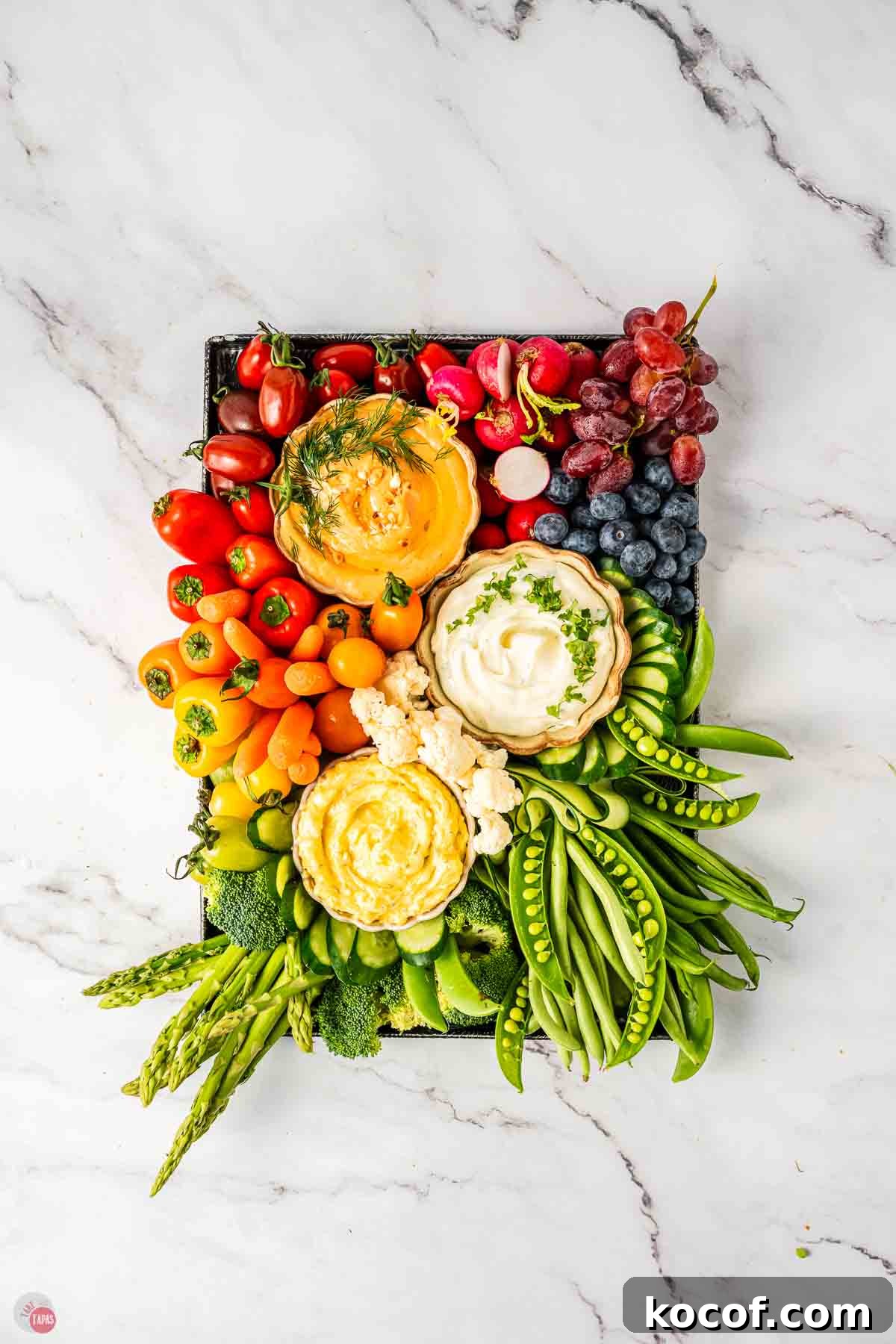 fresh rainbow colored vegetables on a black tray