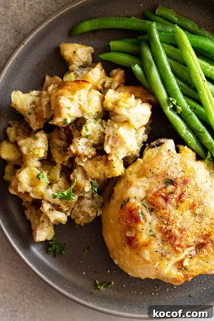 overhead: a serving of chicken and stuffing casserole on a plate with fresh green beans on the side