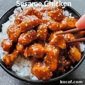 Sesame Chicken on rice in a black bowl with chopsticks