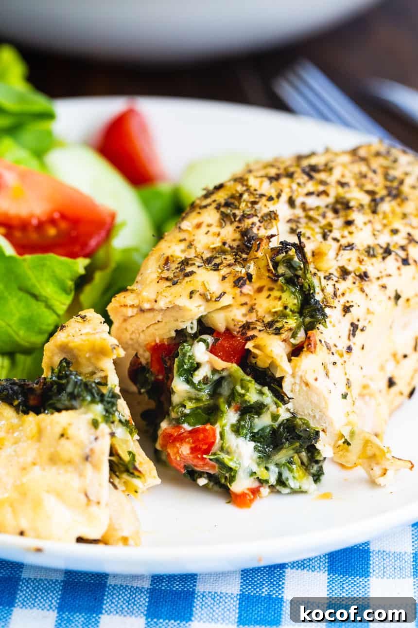 Spinach and Artichoke Stuffed Chicken on a white plate.
