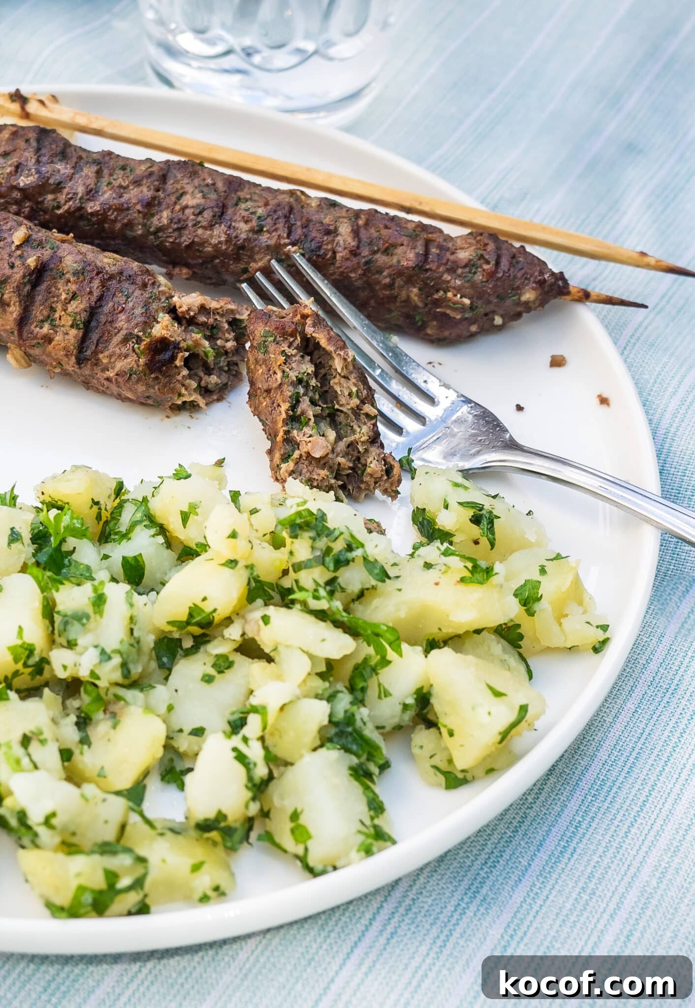 Authentic Kafta Kebab Recipe: Juicy Middle Eastern Grilled Skewers 6 Plate of Kafta kebabs served with potato salad.