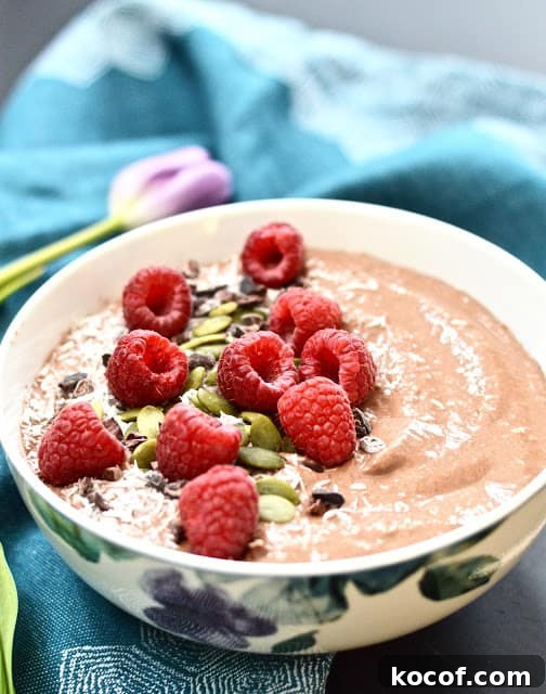 Chocolate Raspberry Smoothie Bowl Recipe for a Creamy Breakfast 3 A chocolate raspberry smoothie bowl topped with shredded coconut and fresh raspberries.