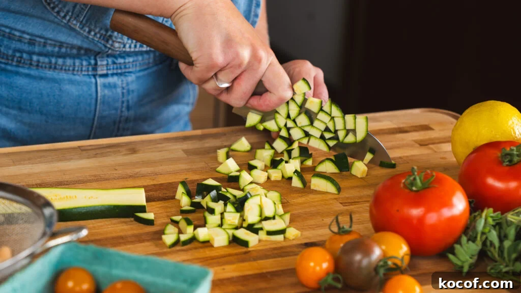 Dicing up fresh zucchini for a delicious zucchini, tomato and white bean salad