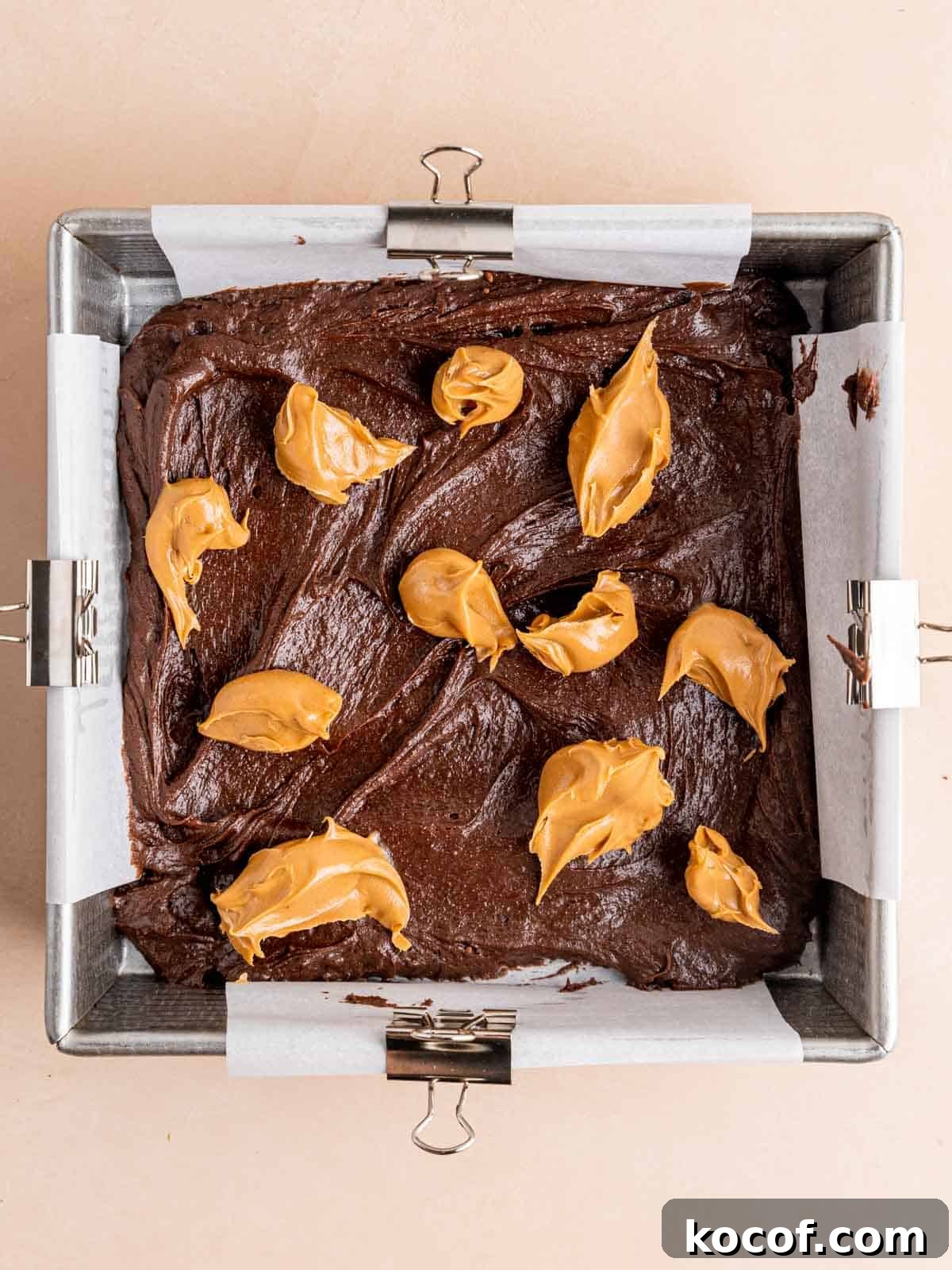 Homemade Chocolate Peanut Butter Brownies Recipe 7 Brownie batter in an 8x8 inch pan with spoonfuls of peanut butter on top.