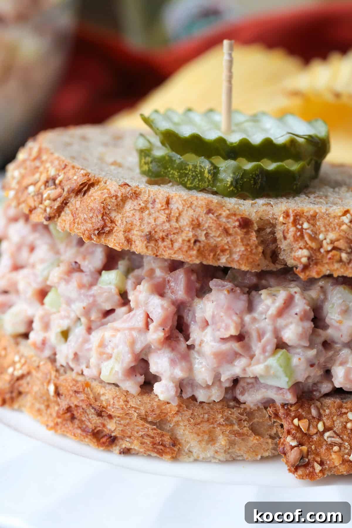 sandwich with pickles on top with a toothpick