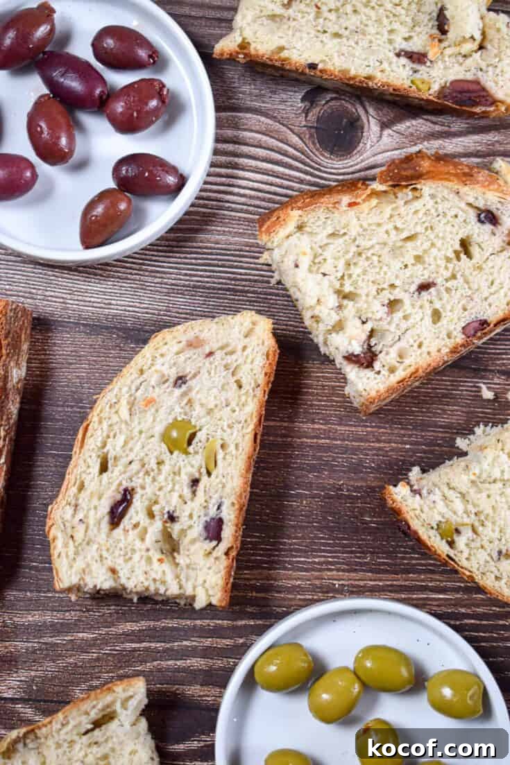 Slices of olive bread in instant pot are laid out with red and green olives