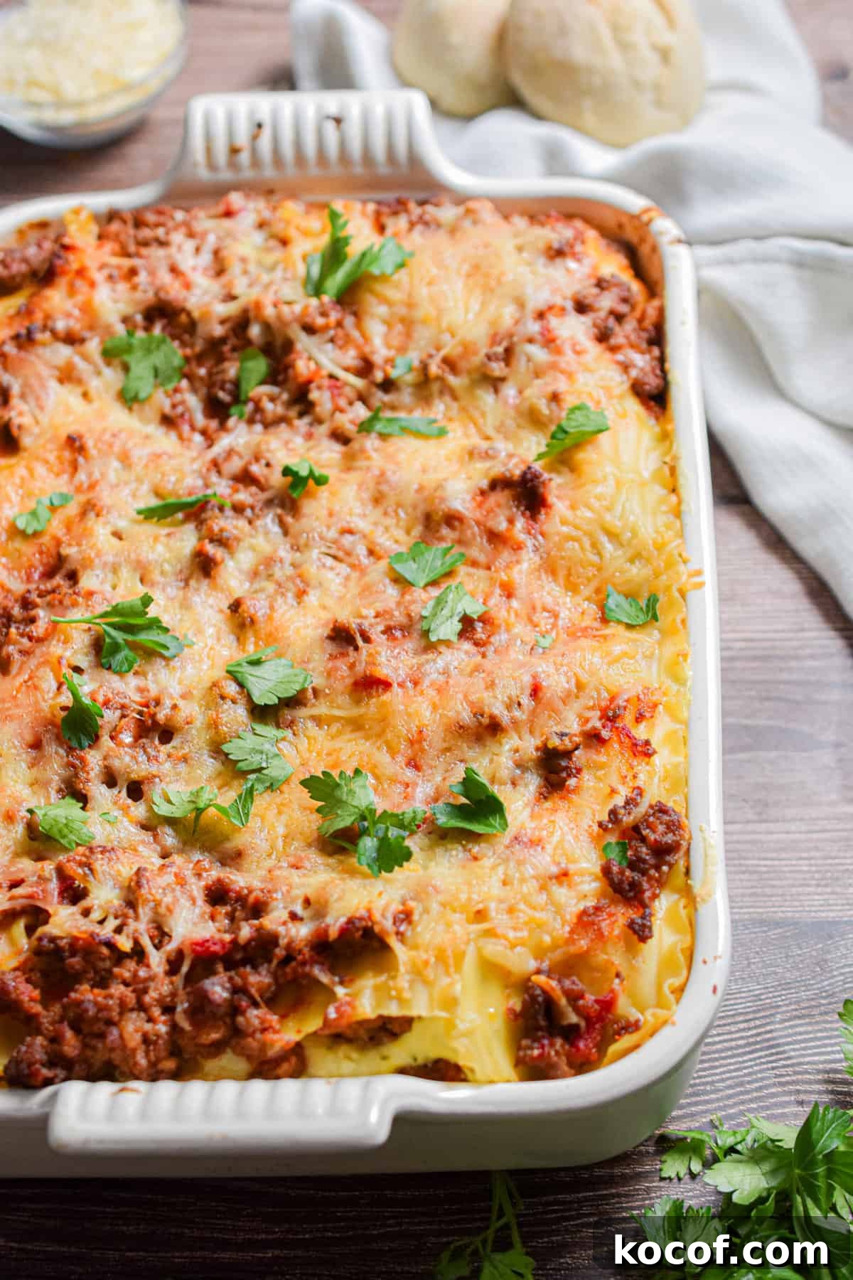 The meat lovers lasagna is on a table with a napkin in the background.