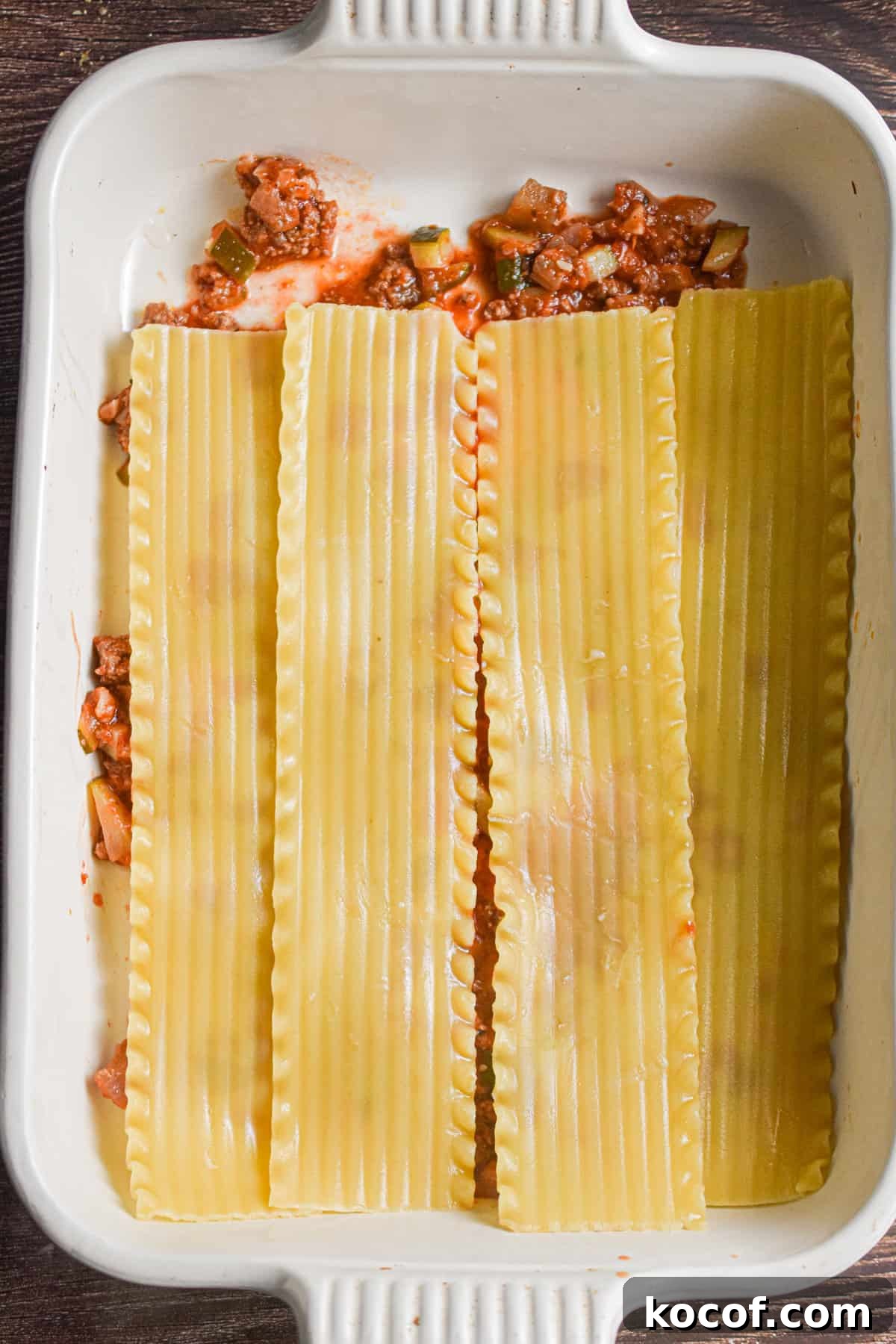Lasagna noodles are added on top of the tomato sauce.