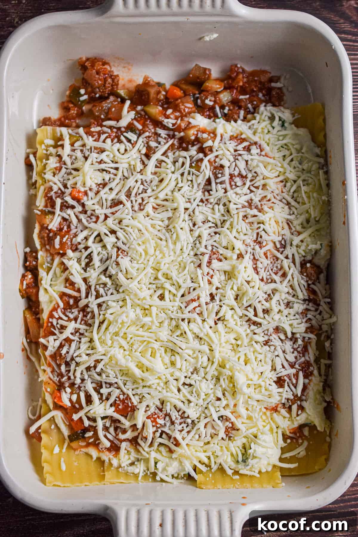 Mozzarella cheese is sprinkled on top of the meat sauce.