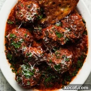 Italian meatballs in marinara sauce, topped with grated cheese and herbs.