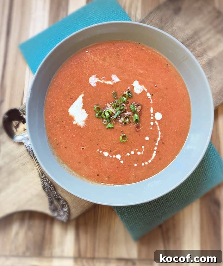 Quick Homemade Tomato Soup Recipe for Comfort and Flavor 3 overhead view of bowl of soup on cutting board.