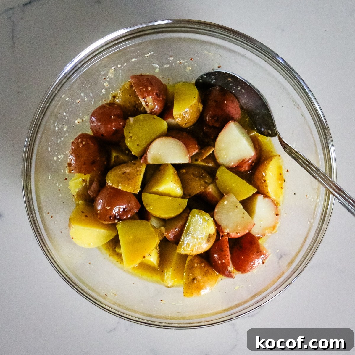 Lemon Dill Tuna & Potato Salad with Light Vinaigrette 9 A clear bowl filled with seasoned potatoes.