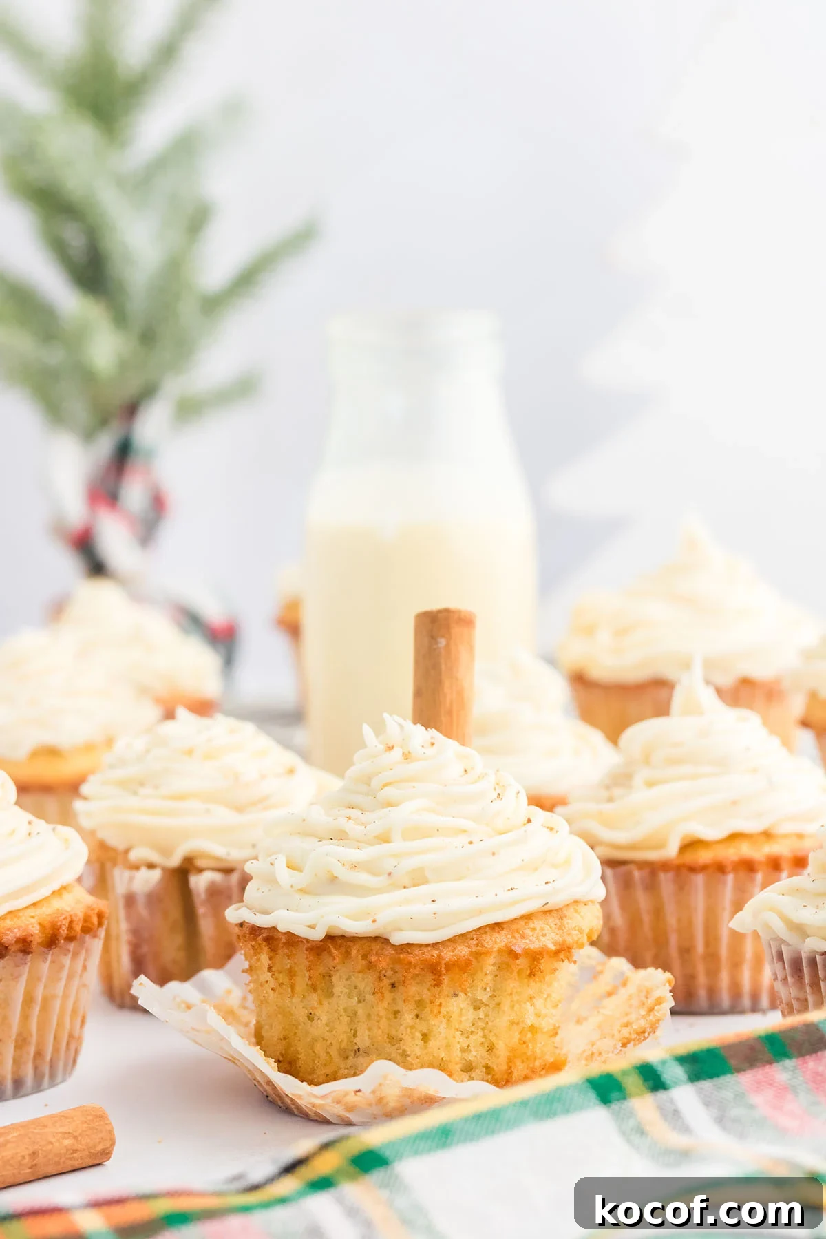 Eggnog cupcakes in cupcake liners topped with eggnog buttercream.
