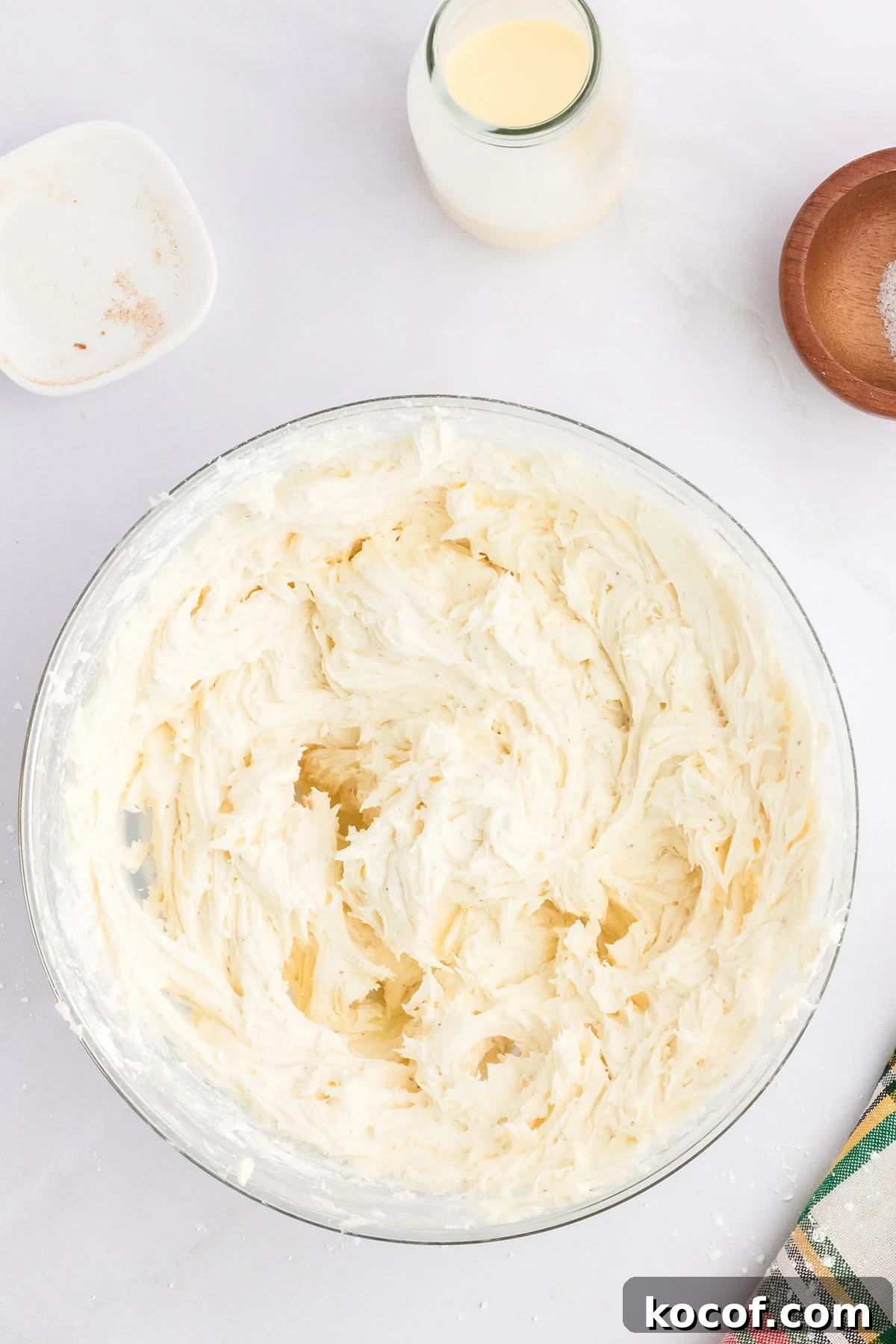 Eggnog buttercream frosting in a glass mixing bowl.