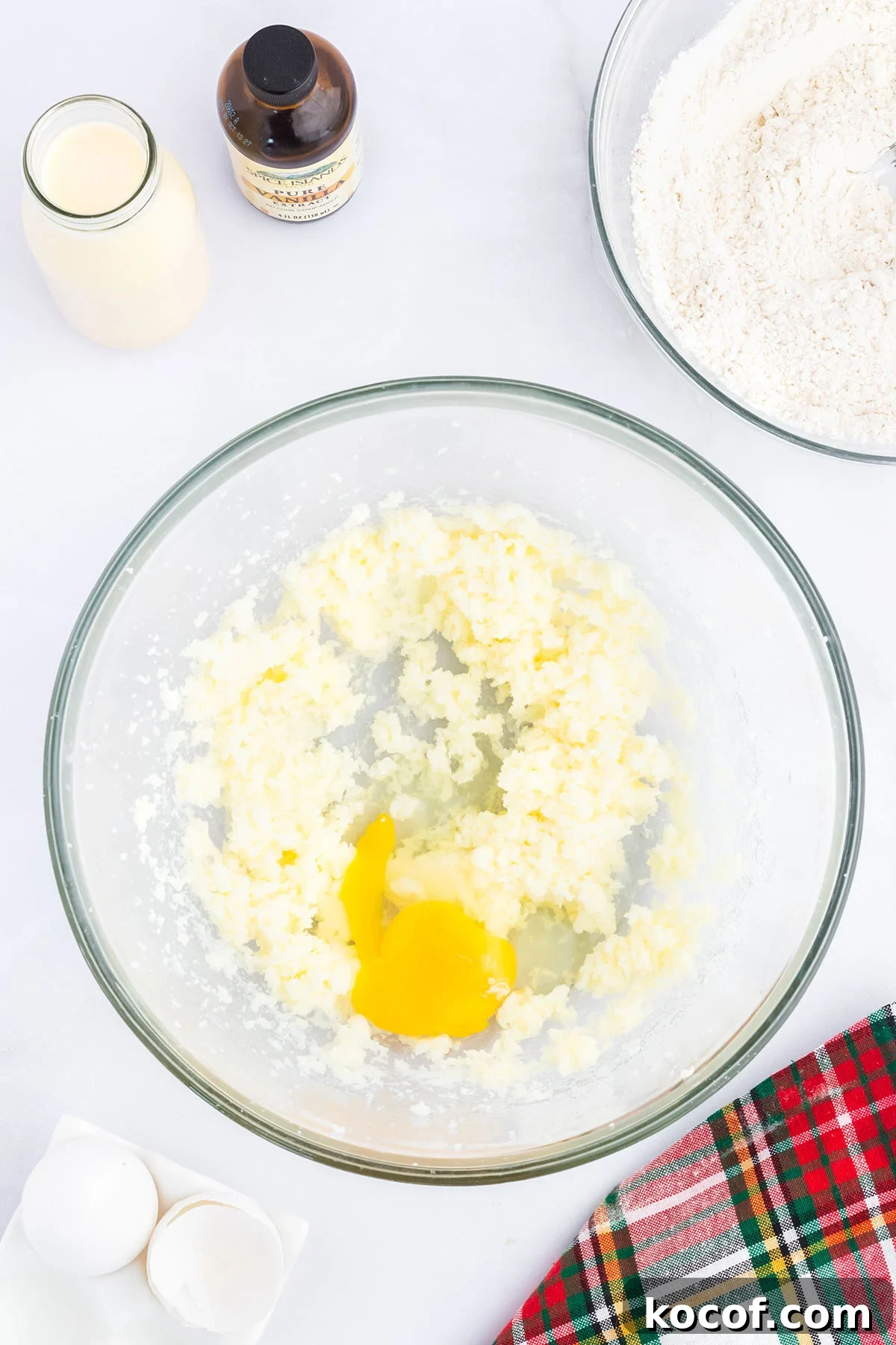 Eggs added to the butter sugar mixture in glass mixing bowl.
