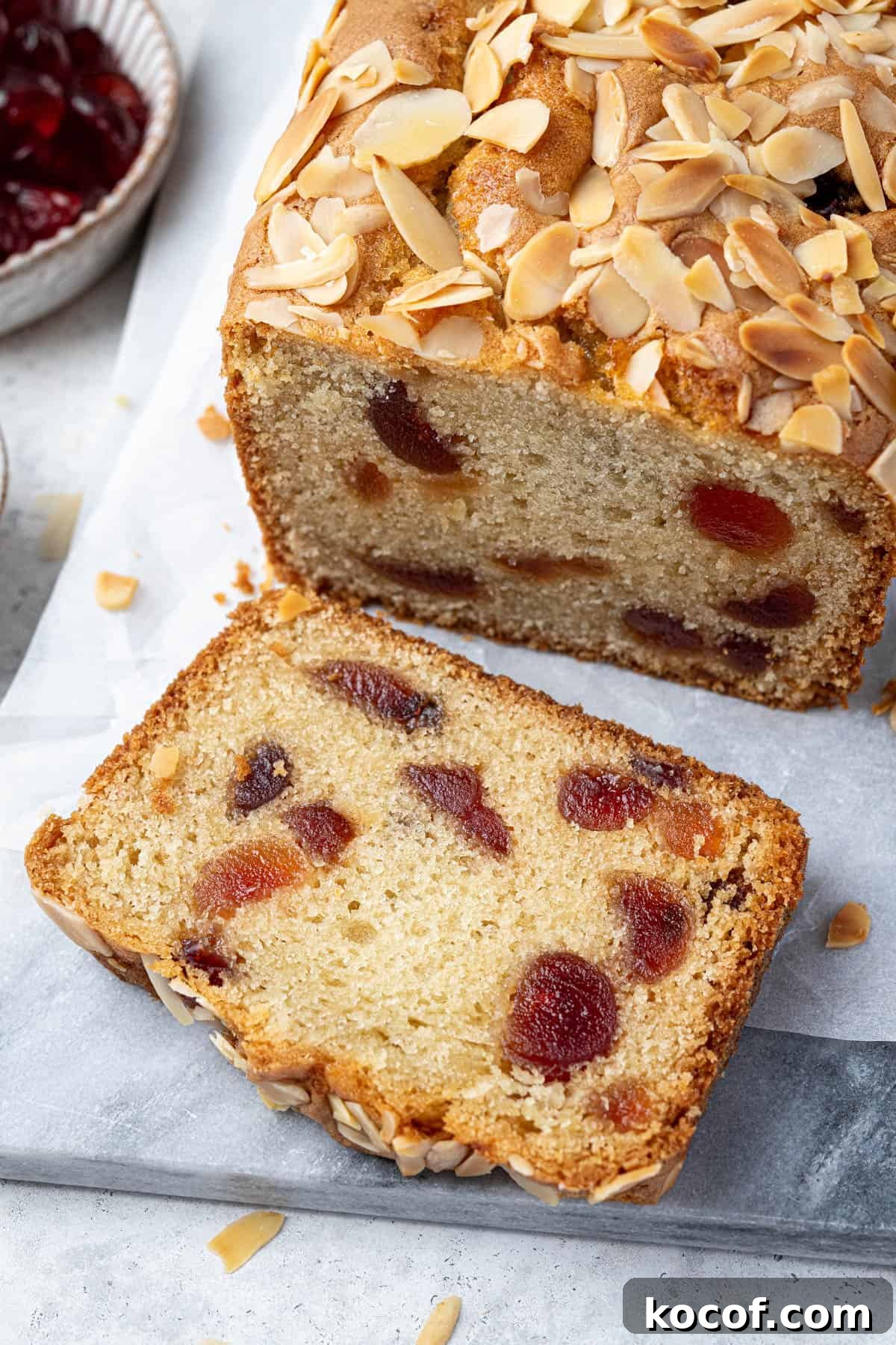 Close up of a slice of vegan cherry almond loaf cake.