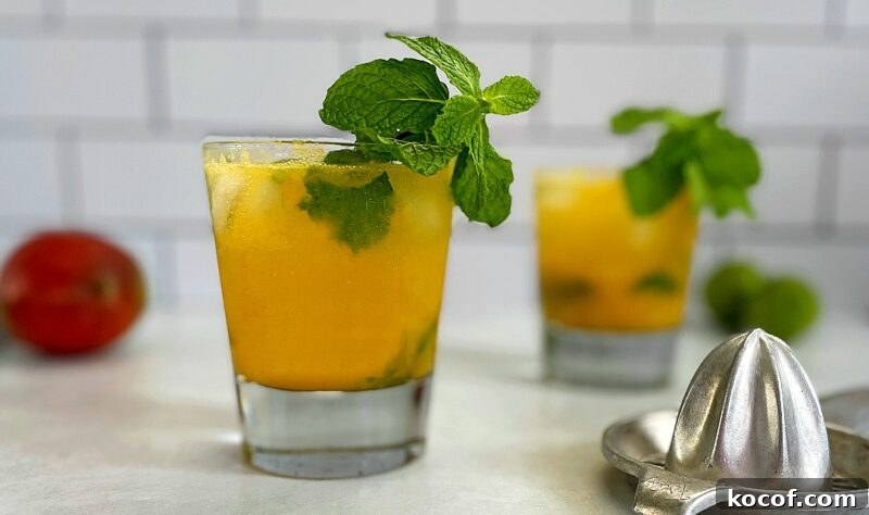 Refreshing Mango Mojito Recipe: Tropical Cocktail Guide 2 Mango mojitos with mint garnish.
