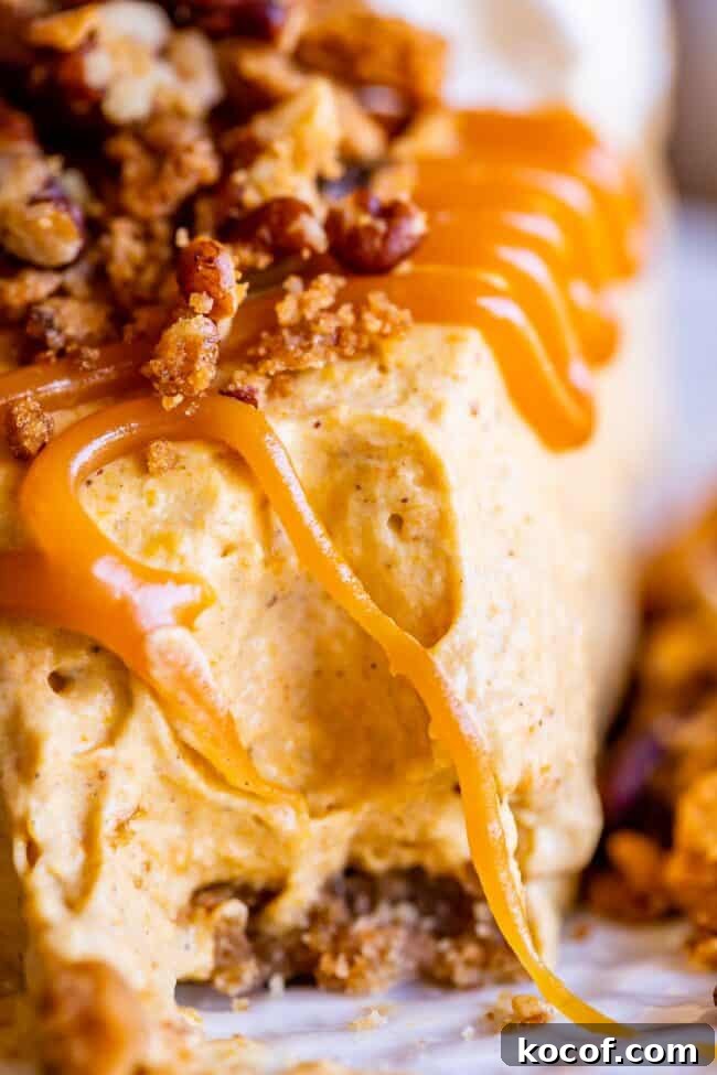 close up shot of a bite taken out of no bake pumpkin cheesecake with caramel sauce.