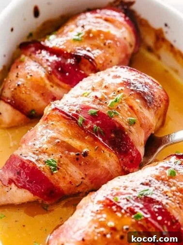 Bacon wrapped chicken breasts in a baking dish.