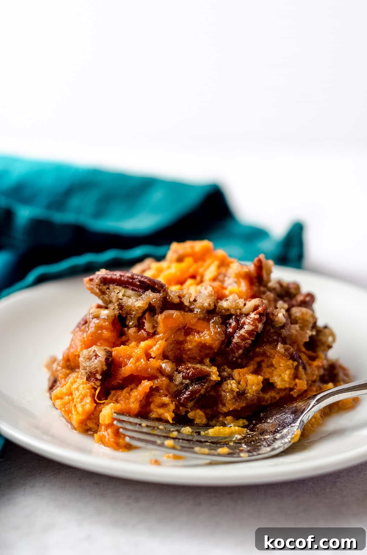 A serving of sweet potato casserole topped with pecans.