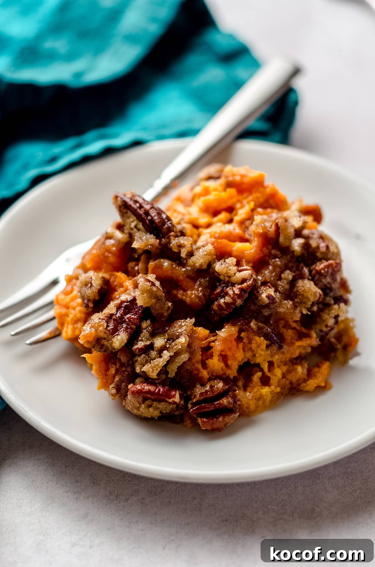A scoop of sweet potato casserole on a white dish.