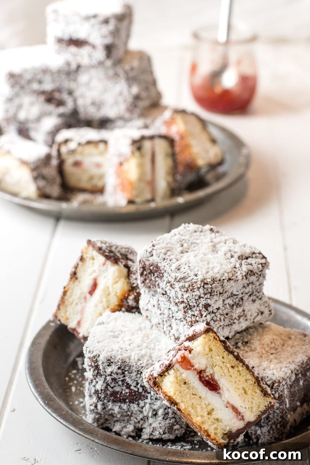gluten-free lamintons with chocolate and coconut coating stacked on rustic pie tins