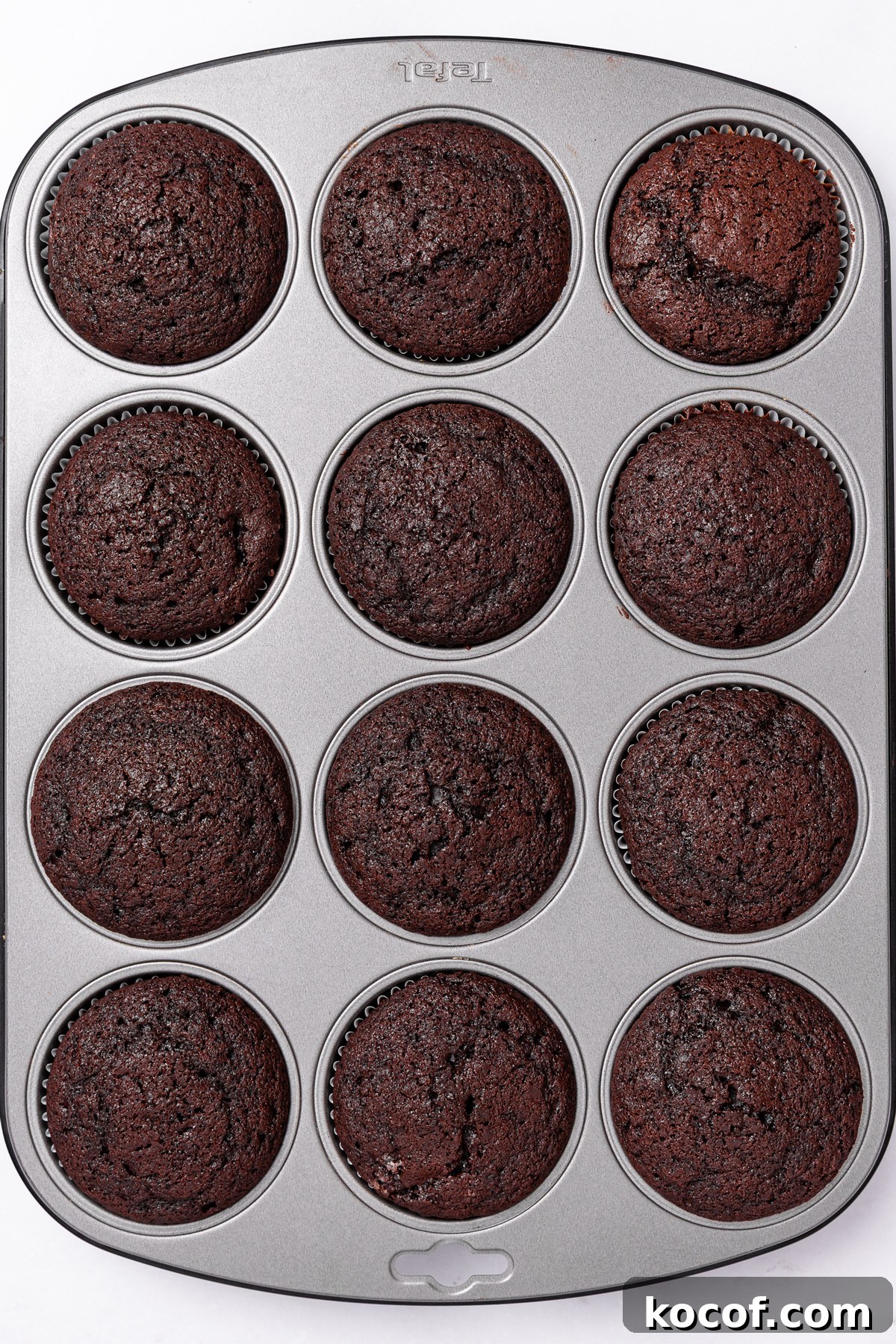 Decadent Chocolate Strawberry Cupcakes with Fresh Berry Frosting 5 freshly baked chocolate cupcakes in a cupcake pan