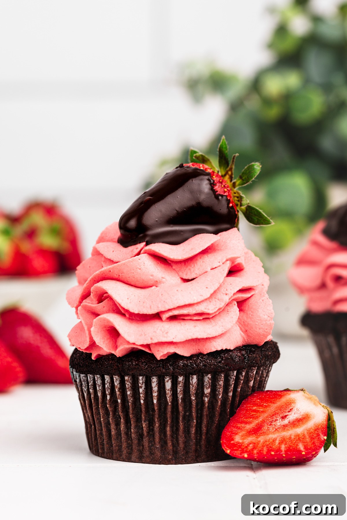 Decadent Chocolate Strawberry Cupcakes with Fresh Berry Frosting 8 chocolate strawberry cupcakes with strawberry frosting on a table