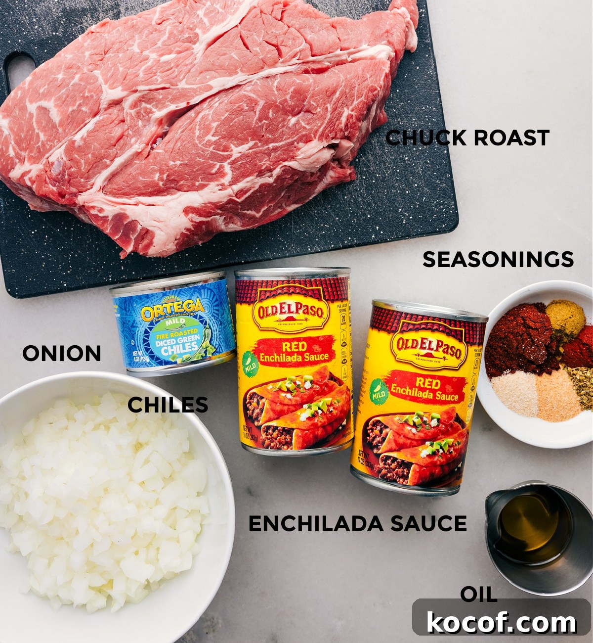 The Best Shredded Beef Tacos Recipe All the ingredients in this recipe prepped out for easy assembly including the meat, enchilada sauce, seasonings, onion, chiles, and oil.