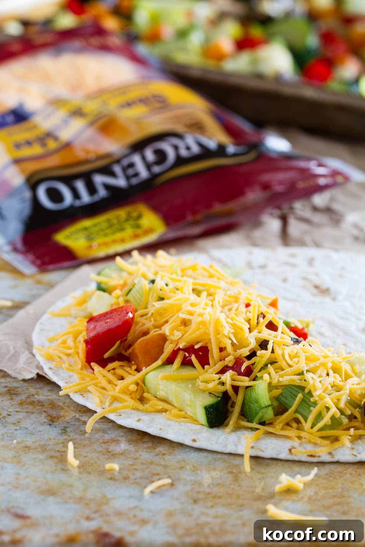 Filling a tortilla with cheese and roasted vegetables.