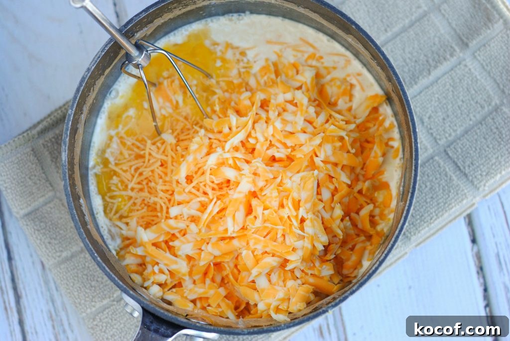 Creamy Homemade Macaroni and Cheese Recipe for Comforting Dinners 4 Hands stirring macaroni and cheese