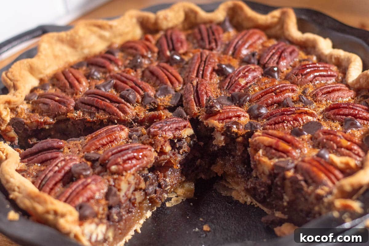 Chocolate Chip Pecan Pie Recipe with Gooey Chocolate Filling 11 Close-up of pecan pie with chocolate chips recipe, showing melted chocolate and crunchy pecans in buttery crust.