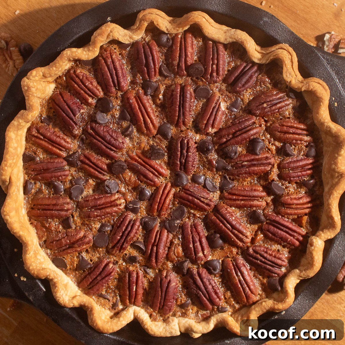 Chocolate Chip Pecan Pie Recipe with Gooey Chocolate Filling 3 Golden chocolate chip pecan pie recipe baked in a cast iron pan with pecans and chocolate chips on top.