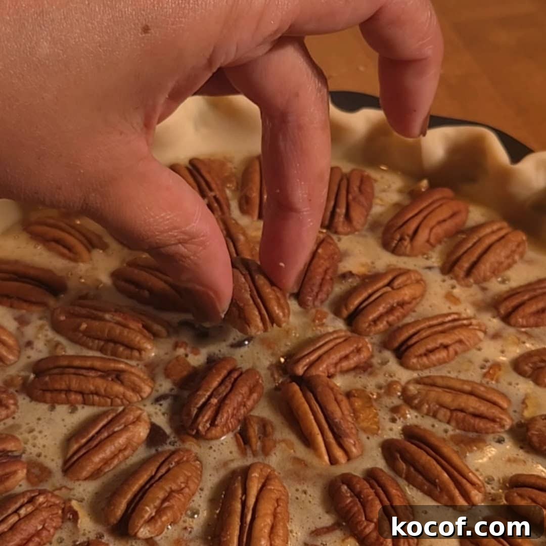 Chocolate Chip Pecan Pie Recipe with Gooey Chocolate Filling 9 Unbaked chocolate chip pecan pie with pecans and chocolate chips arranged over brown sugar filling before baking.