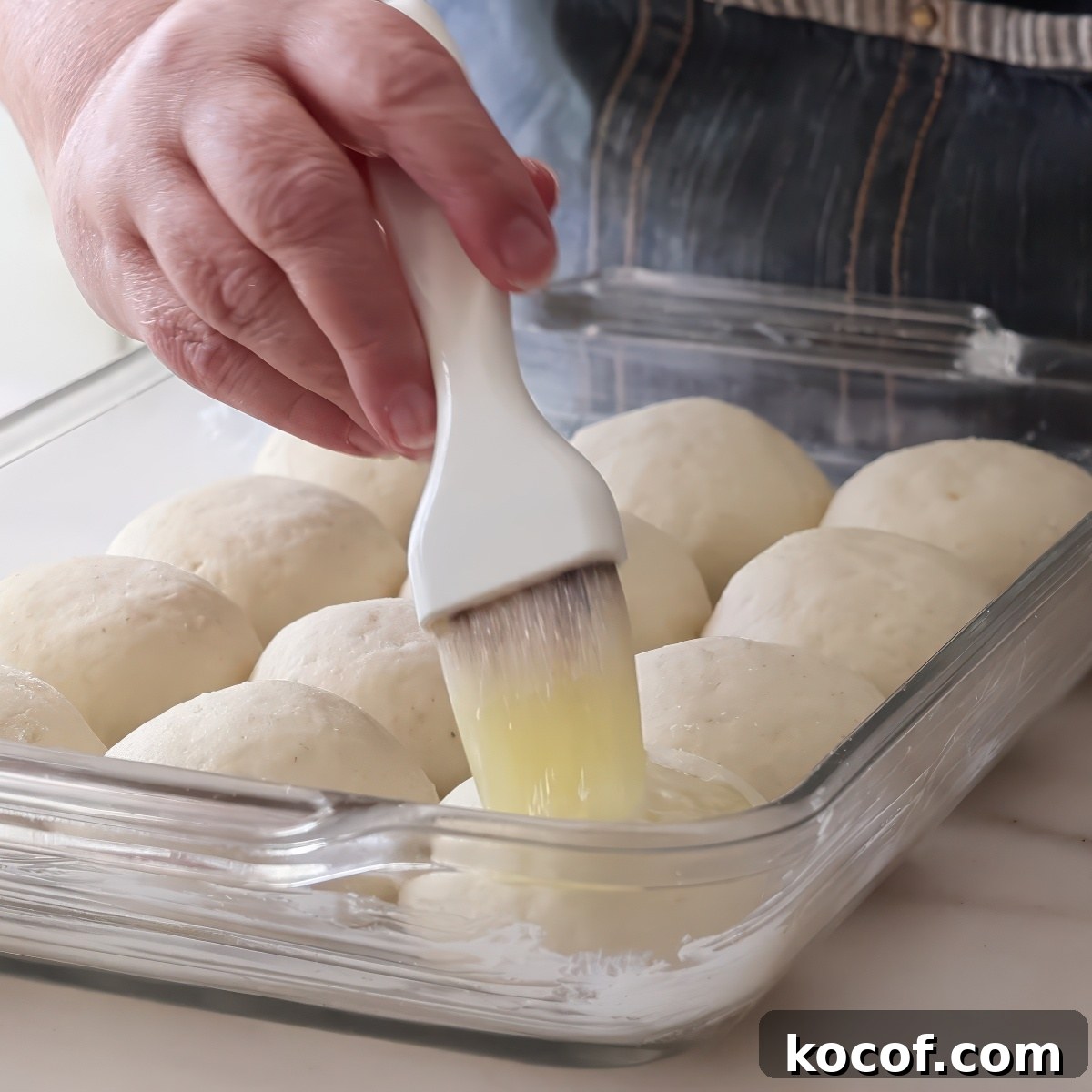 brushing unbaked rolls with butter.