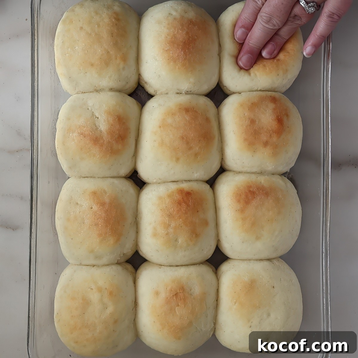pressing hand down on roll in glass pan.