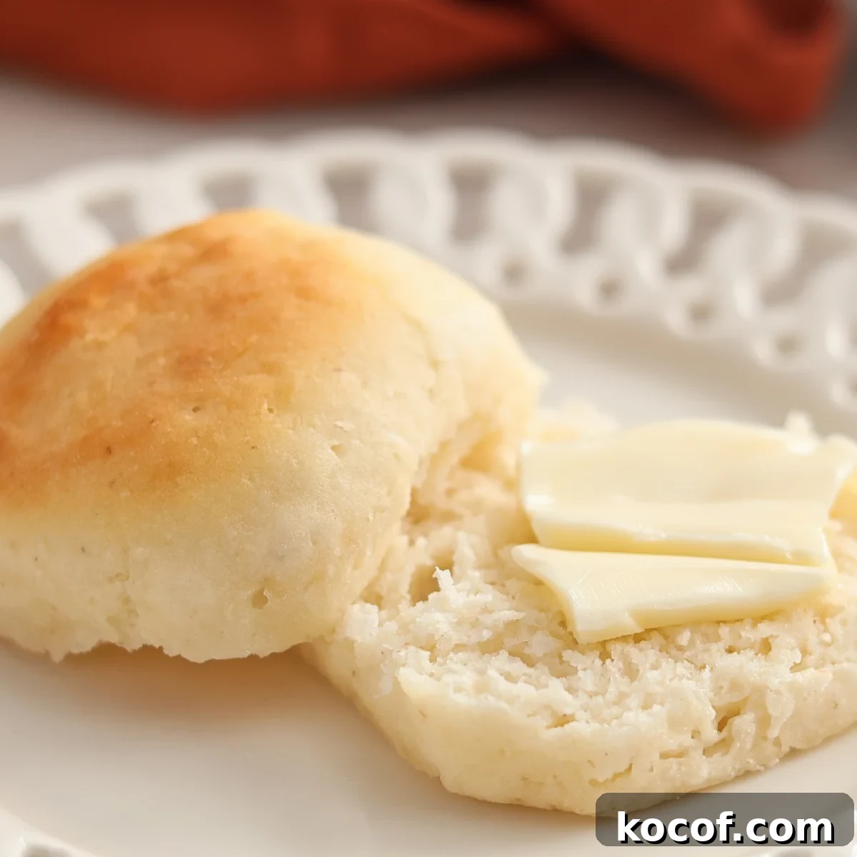 roll split open and bottom half with butter on top.