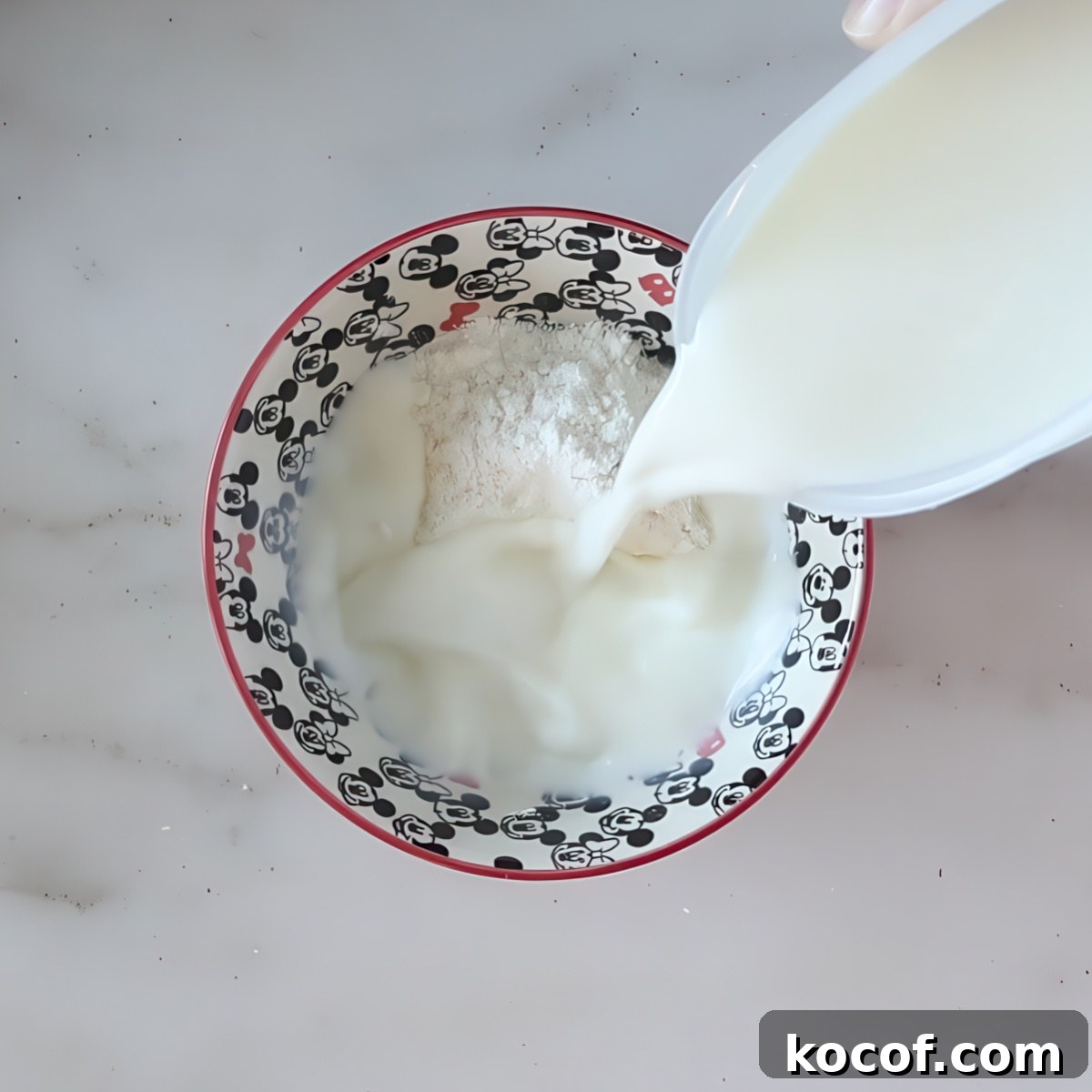 pouring milk into flour in small bowl.