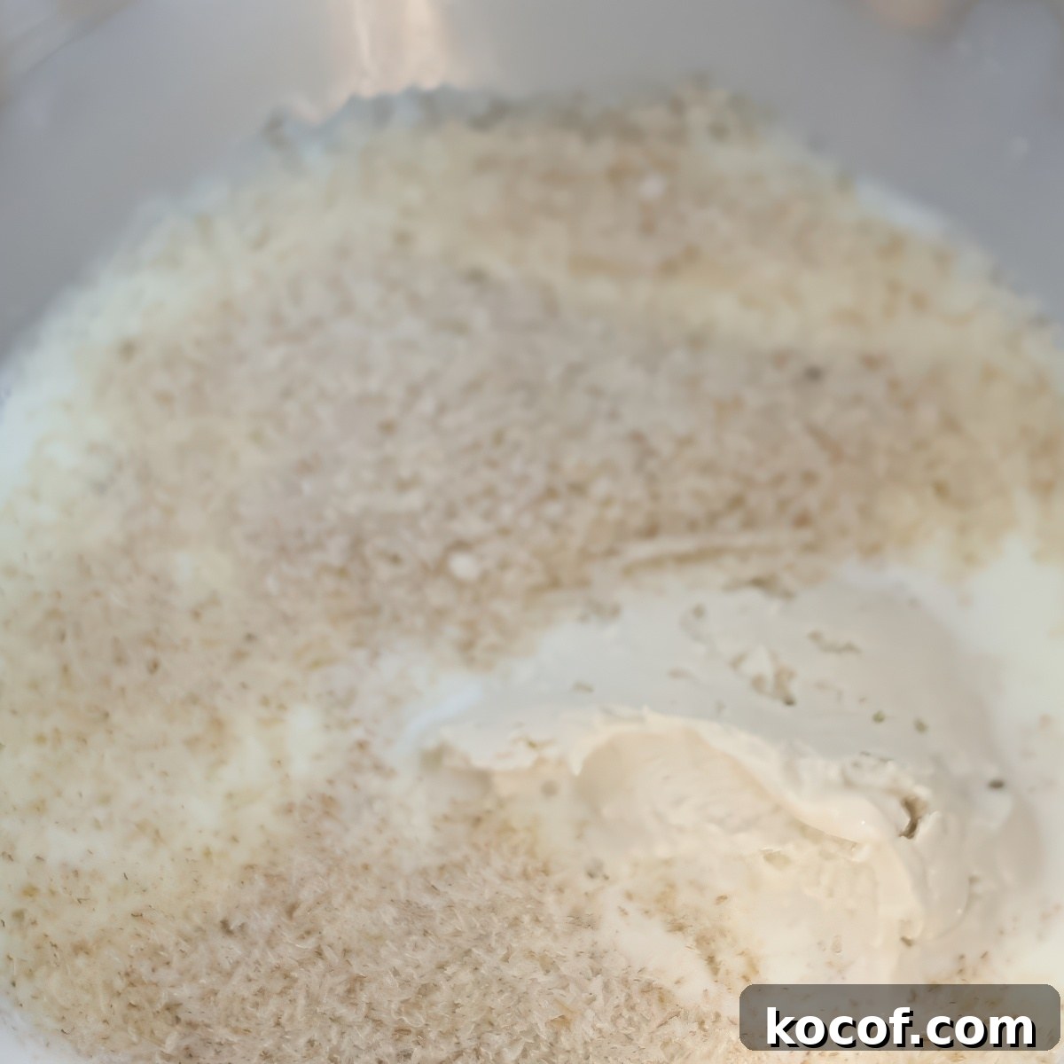 psyllium husks and sourdough starter in milk in stainless steel bowl.