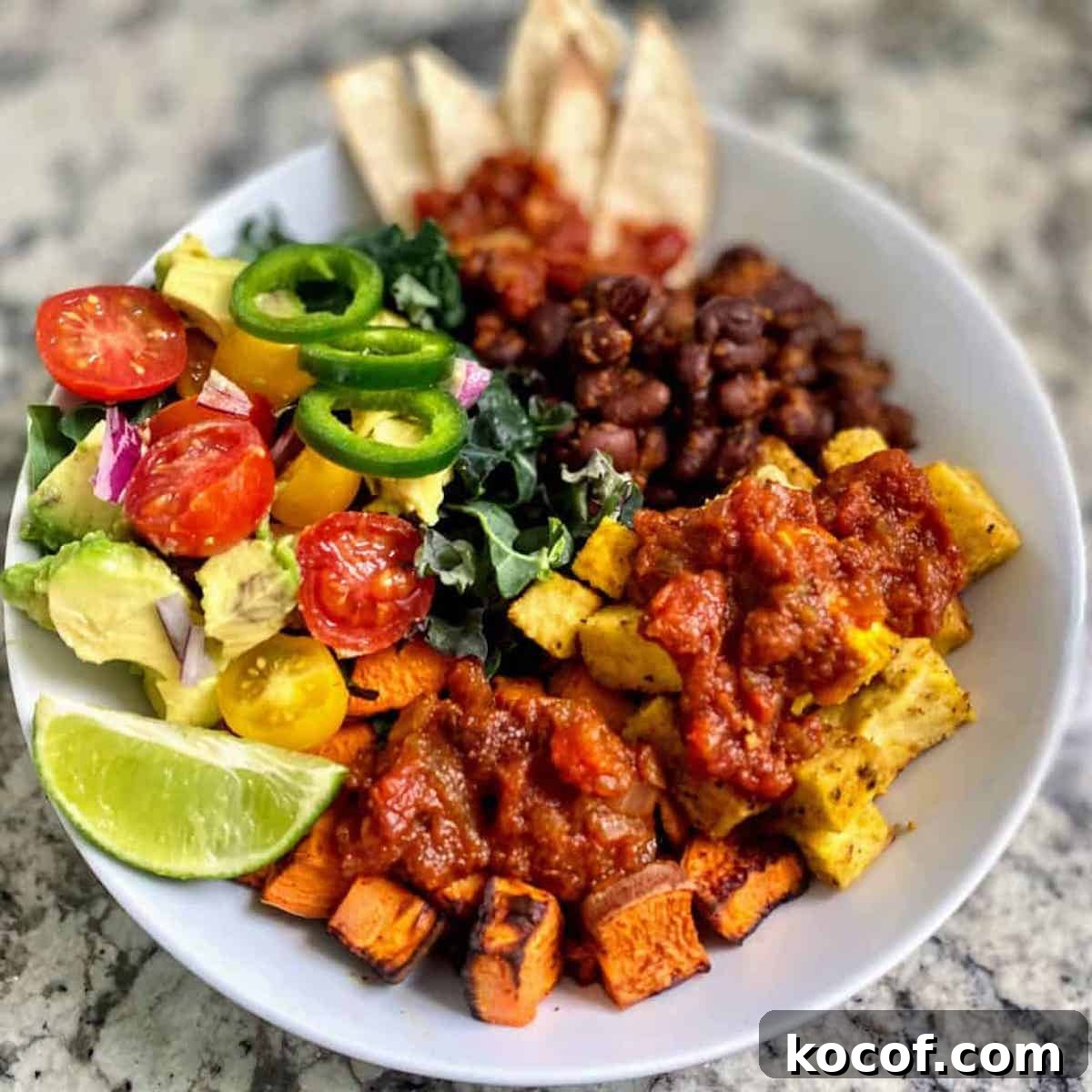 Hearty Vegan Breakfast Bowl with Quinoa, Avocado & Tofu 8 Vegan breakfast bowl recipe on a table served with a wedge of lime.