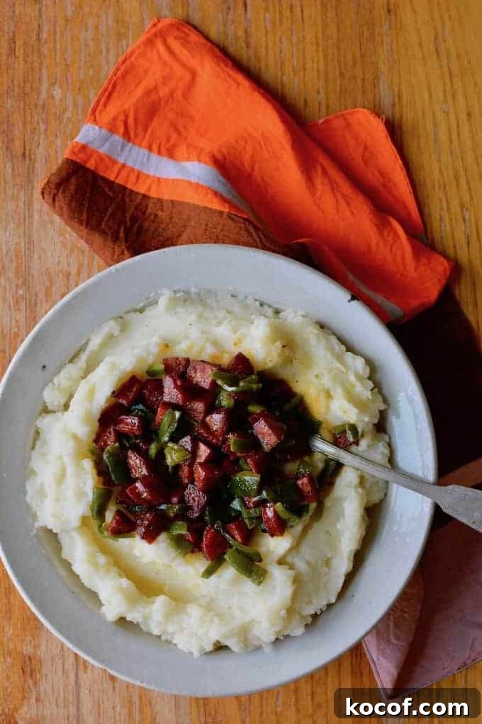 22 Delicious Easter Dinner Ideas That Aren’t Ham 18 A bowl of mashed potatoes with chorizo and poblano pepper on top and a spoon sticking into the bowl.