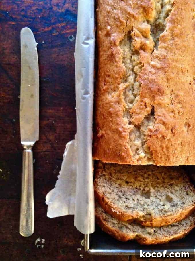 22 Delicious Easter Dinner Ideas That Aren’t Ham 22 A pan of banana bread sitting on a wood table with two slices cut out of it and a butter knife sitting near by.
