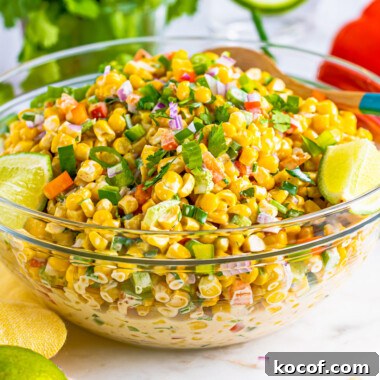 square image of tex-mex corn salad in a glass serving bowl