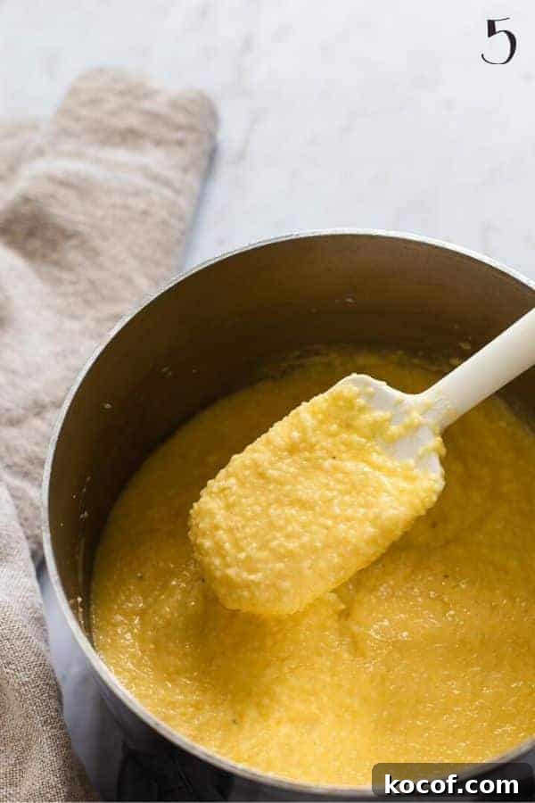Cheesy Grits Casserole Recipe with Crispy Topping 3 grits mixture in a pan with a white spatula
