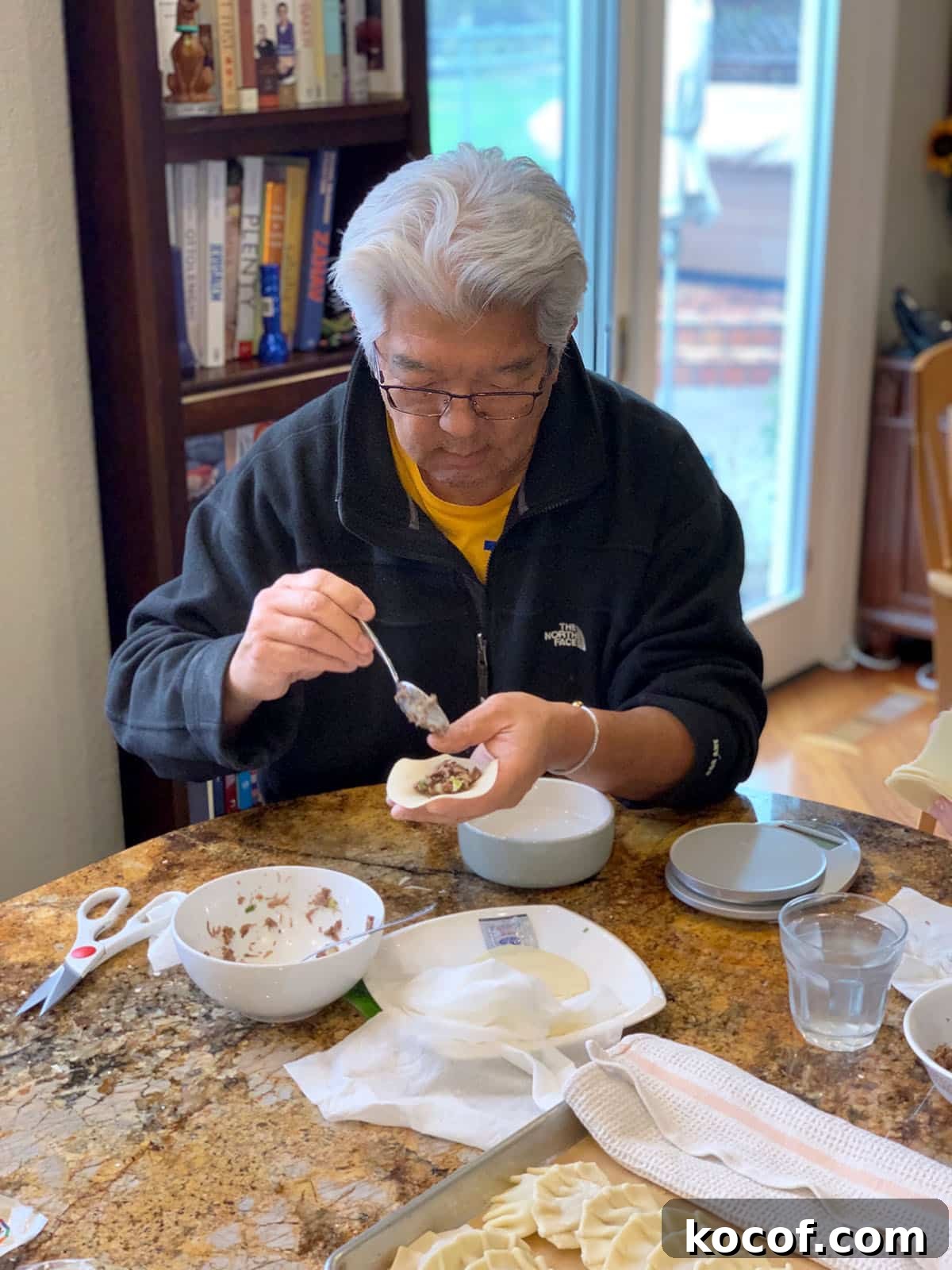 Korean Beef Mandu Dumplings Recipe: Authentic Jew Mandu Guide 8 Doug folding a Jew Mandu beef dumpling at a kitchen counter.