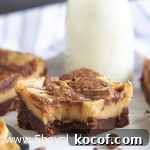 peanut butter cheesecake brownie with a bite out of it and a glass of milk